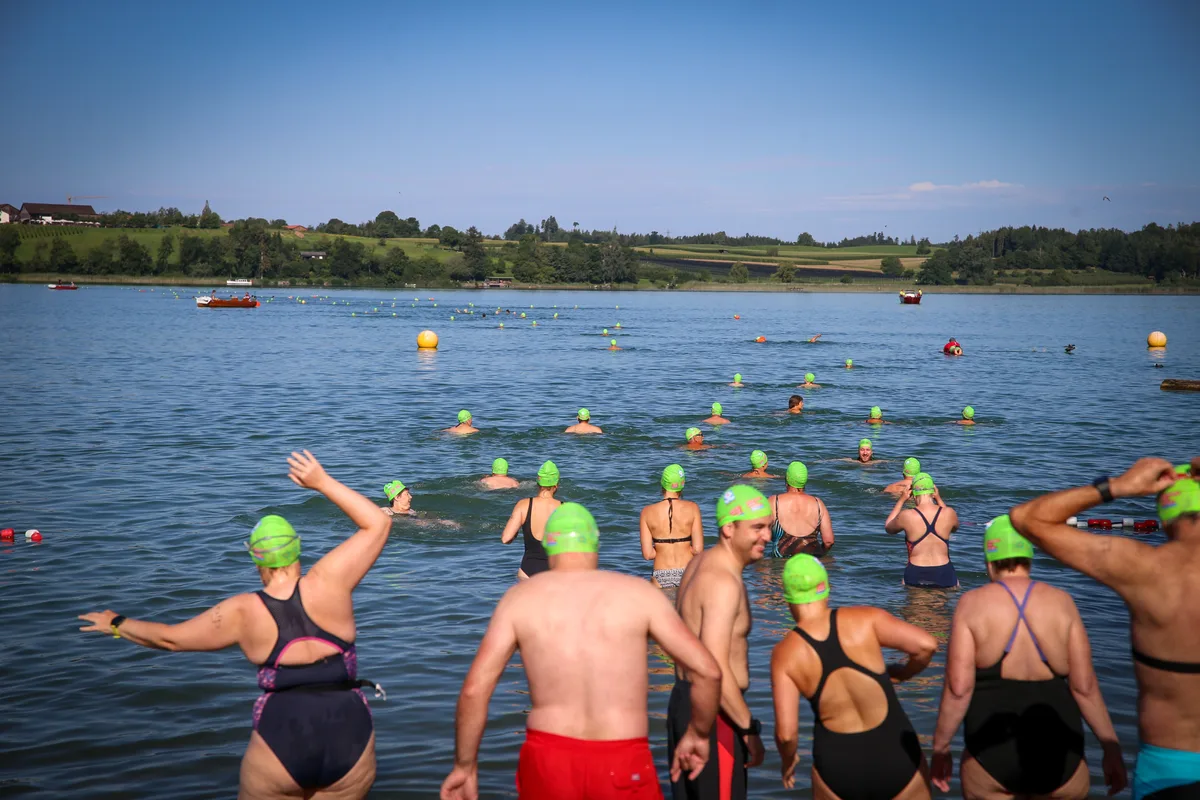 Man sieht eine Gruppe von Menschen, die in den Pfäffikersee reinlaufen.